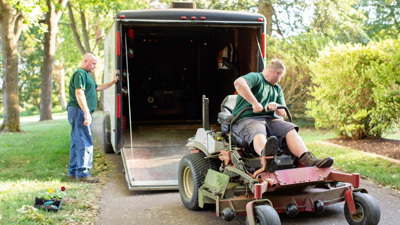 Ron and Ronnie unloading a mower from a trailer